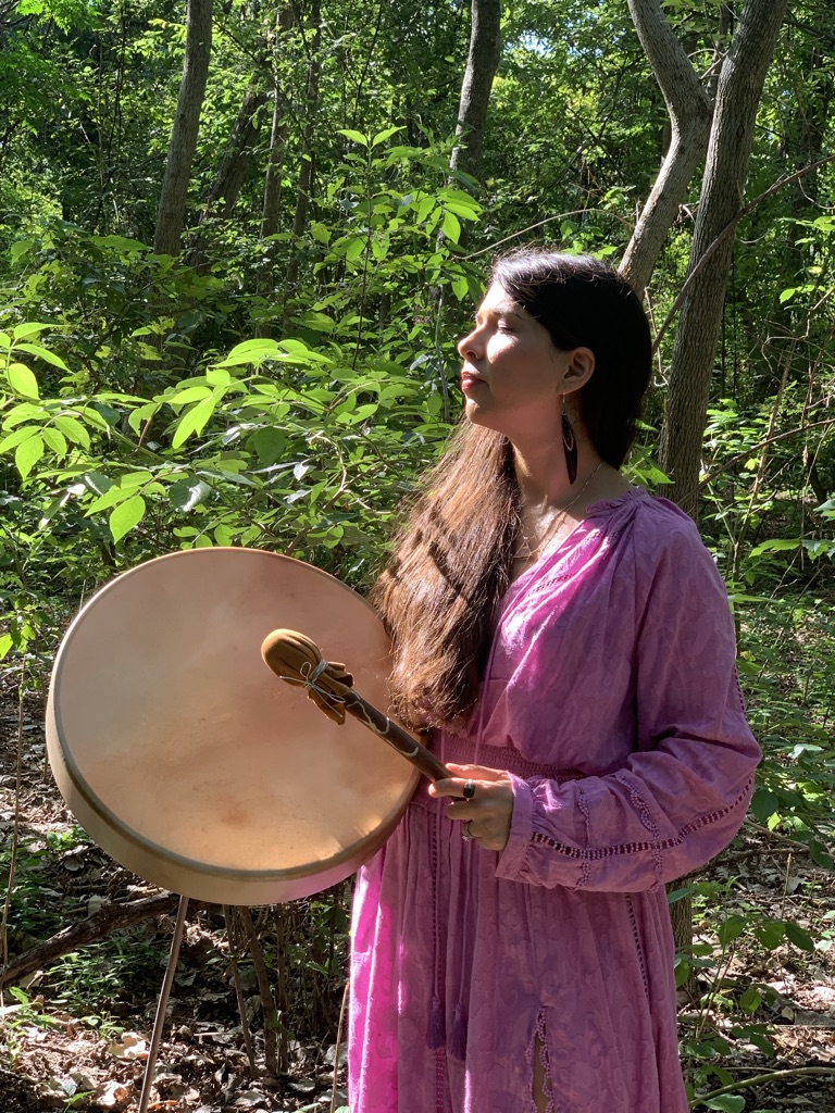 Laura Maesaka with her ceremonial drum in the forest